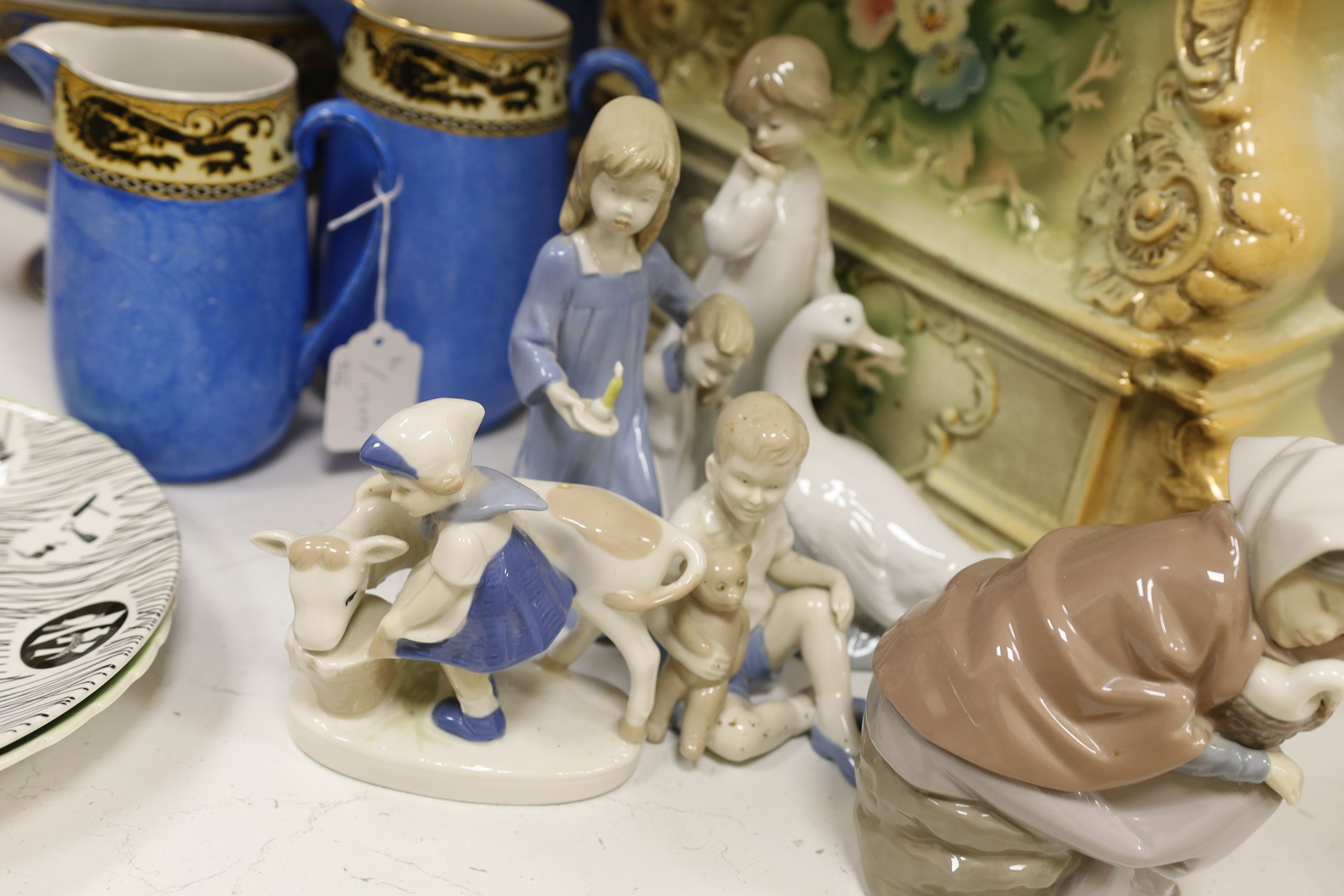 Six mixed Nao and other similar figures, a Homemaker plate, a Carltonware plate, four graduated jugs, and two pedestal bowls, a pair of mottoware candlesticks and a French china mantel clock